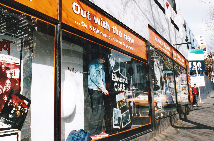 Admin thumb jonathan bree putting up a display in real groovy records in the diy era of the label photo by gareth shute